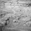 Oblique aerial view centred on the remains of the hut-circle, small cairns and field system with farmstead, field-system, rig and small cairns adjacent, taken from the ENE.