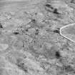 Oblique aerial view centred on the remains of the field-system and small cairns with hut-circle and small cairns adjacent, taken from the NW.