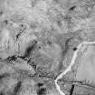 Oblique aerial view centred on the remains of the farmstead, field-system, rig and small cairns, taken from the WSW.