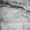 Oblique aerial view centred on the remains of the fort with power station adjacent, taken from the SE.