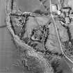 Oblique aerial view centred on the remains of the castle with Castle Mains house and school adjacent, taken from the SW.
