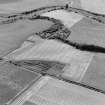 Oblique aerial view of Culvennan, taken from the NNE, centered on enclosure and cropmarks.