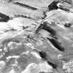 Broom Hill, oblique aerial view, taken from the WSW, centred on the remains of a fort and enclosure, with cultivation remains surrounding and an enclosure to the top of the photograph.