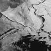 Oblique aerial view of Fiddleton centred on the remains of two scooped settlements, cultivation terraces and a cottage, taken from the S.