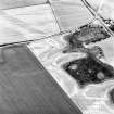 Gilchrist, oblique aerial view, taken from the NE, centred on the cropmarks of a promontory fort.