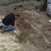 Photograph taken during the Council for British Archaeology 1987 Summer School. Working shot of the excavations, including the excavation of a skeleton.