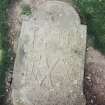 Forgan, St. Fillans Churchyard.
General view of gravestone with arched top. Rows of tools and emblems including; ring-headed cross(?) or mirror(?), hammer, trowel, mallet, pick and chisel. Also; hourglass, crossed bones and crossed spades.