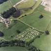 Oblique aerial view centred on the remains of the chambered cairn with farmsteading adjacent, taken from the NW.