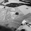 Oblique aerial view centred on the cropmarks of an enclosure and trackways with round house, enclosure, pits, cultivation remains, pit-alignment long barrow, square barrow and plantation bank adjacent, taken from the WNW.