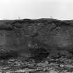 Photograph showing coastal erosion of structural features.