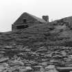 Photograph showing coastal erosion of structural features.