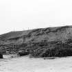 Photograph showing coastal erosion of structural features.