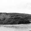 Photograph showing coastal erosion of structural features.