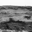 Photograph showing coastal erosion of structural features.
Plate iv, p90 GAJ 1985 vol.2  Detail of erosion, showing flagging and walls.