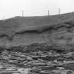 Photograph showing coastal erosion of structural features.