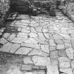 Excavation photograph : east range - room 4 paved floor, from north.