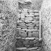 Excavation photograph: Containing wall that surrounds north east side of chamber.