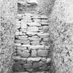 Excavation photograph: Containing wall that surrounds north east side of chamber.