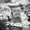 Excavation photograph showing view outward through entrance way, crossways timbers originally extended to right of ranging rods ( cut away during 1973 excavation)
Duplicate photographic print available in MS/1179/2
