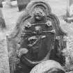 Detail of standing tombstone dedicated to Alex Reid dated 1764, St Mary's Church burial ground, Banff. Symbols visible include angel blowing trumpet out of which banner is flowing.