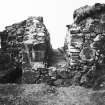 Excavation photograph: west wall of great tower, showing springer of arch and loophole.