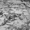 Excavation photograph : pebble pit amid flagstones in settlement area.