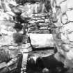 Excavation photograph - Entrance to guard cell, looking outwards into broch entrance passage.
Photographic copy of polaroid print. Copied 1995.