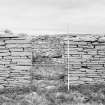 Survey photograph : site 51b - part of front elevation of earlier domestic unit, with internal access to byre; and living area with chimney at either end.