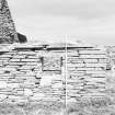 Survey photograph : site 51b - part of front elevation of earlier domestic unit, with internal access to byre; and living area with chimney at either end.