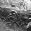 Excavation photograph : section through rubble and soils (f104), from SE.