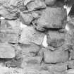 Excavation photograph : detail of rear of upper courses of masonry forming back of fireplace in E range, from N.