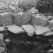 Excavation photograph XIV  view on N side of circular enclosure showing paving next to wall and inner facing.