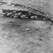 Excavation photograph  -section of cairn material showing natural slope