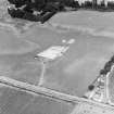 Oblique aerial view of linear cropmarks under excavation.