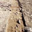 Excavation photograph : area 2 - N-S trial trench, Hut G, after removal of 10cm spit, from N.