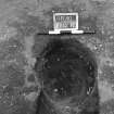 Excavation photograph : trench II - posthole BBQ, excavated, from above, facing north.