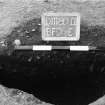 Excavation photograph : trench II - posthole BFD, half section, facing east.