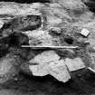 Excavation photograph : section across clay layer f560 overlying slabs f511 and cut by f5, from S.