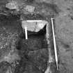 Excavation photograph : grooved stone at top of pit f590, from E.