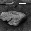 Excavation photograph.  F210 stone sitting over possible feature, from east.