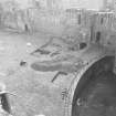 Excavation photograph : W end of courtyard showing location of trenches A and C, from N.
(B&W negatives colour printed)