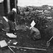 Excavation photograph : area M - working shot of skeleton 1158 with shroud.