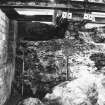 Excavation photograph: area H/X - wall of Storekeepers house showing slope of bedrock.
