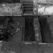 Excavation photograph : area K - E-W partition walls of detention cell exposed to foundation base, from east.