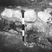 Excavation photograph :  plinth F02 showing southernmost V shaped slot cut into it, from E.