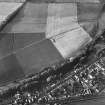 Oblique aerial view of Milton centred on the cropmarks of a cursus with cultivation remains adjacent.