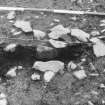 Excavation photograph : f002 - hearth (?) partially excavated showing stone arrangement.