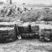 Excavation photograph. Buttressed building at SE end.
Copied from A O Curle photograph album MS/28/461.