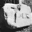 Block of stone bearing crudely incised cross and initials.