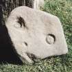 Block of stone bearing incised circular markings.